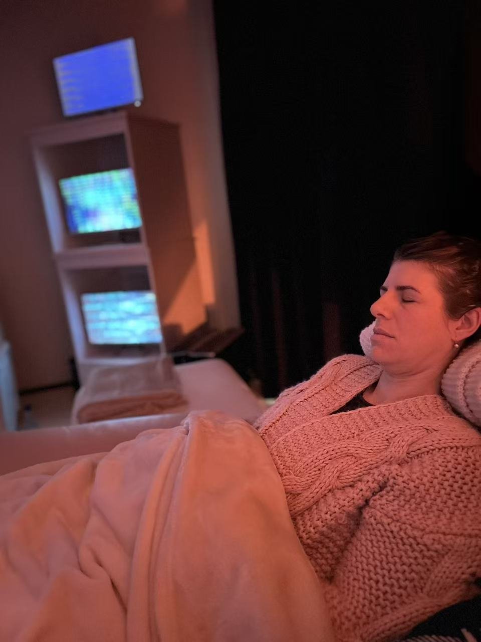 A client resting in the Scalar Lounge at GC Wellness Centre during a private group sound healing session